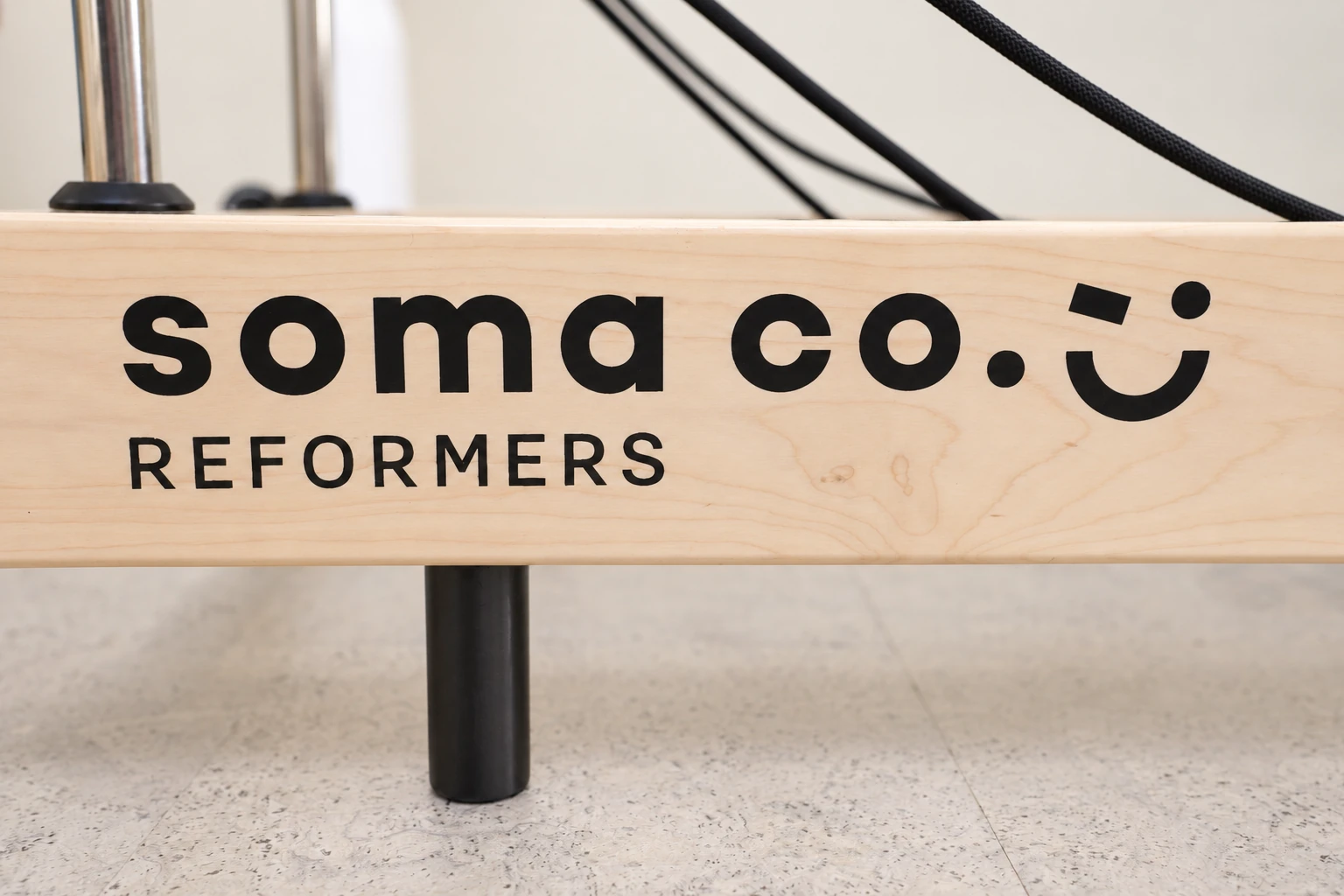 Soma Co. Logo am hellen Holzrahmen