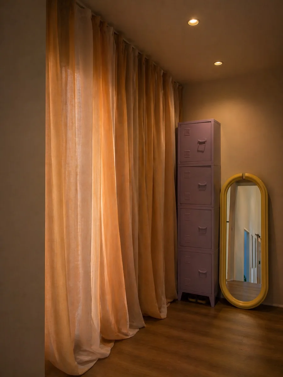 Curtained changing area with lilac lockers and a yellow mirror